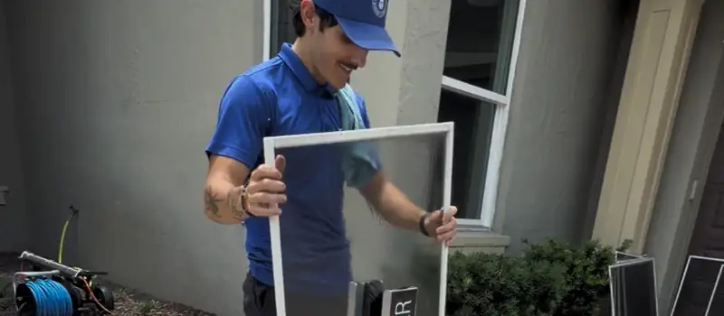 Aquapals technician carrying a window screen