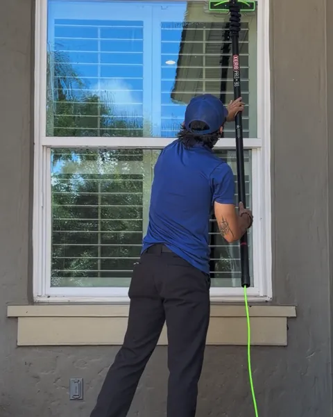 Aquapals technician cleaning a window with a water-fed pole